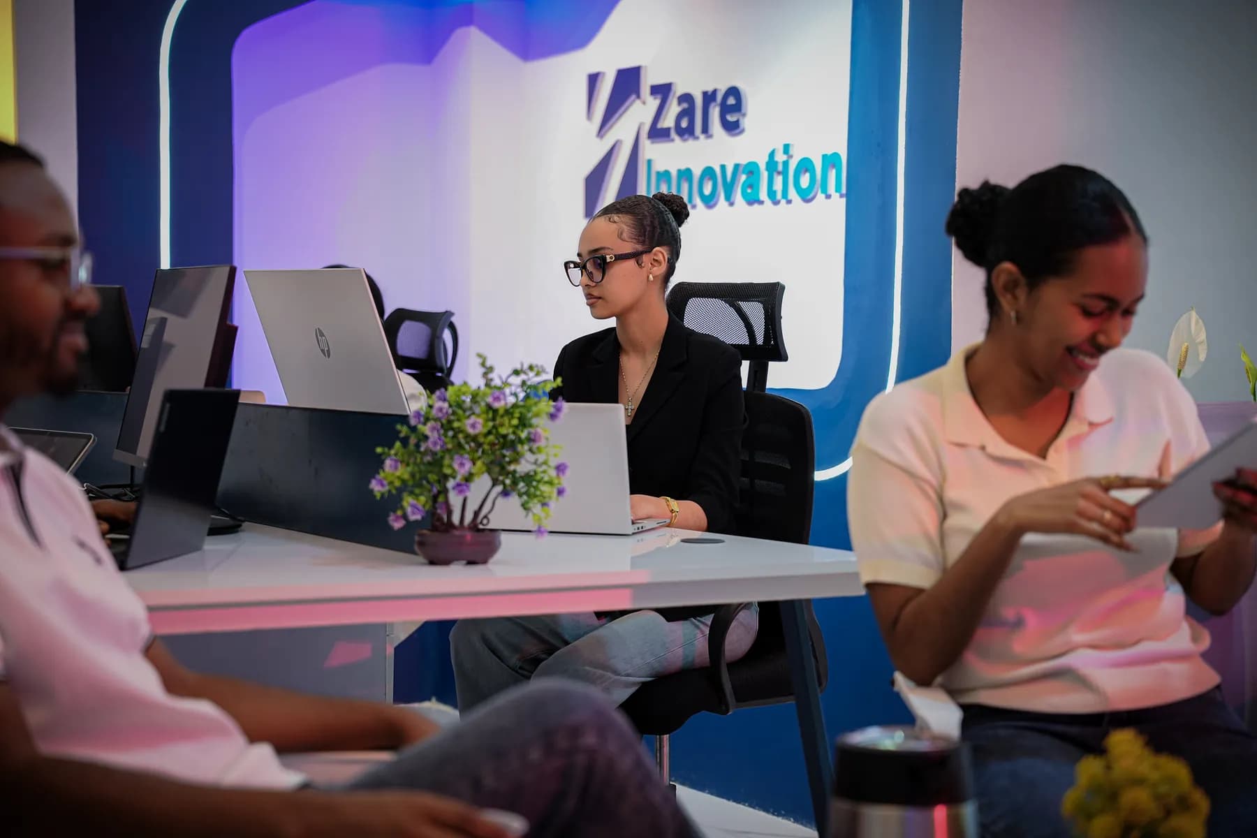 Two Zare team members laughing together at a desk